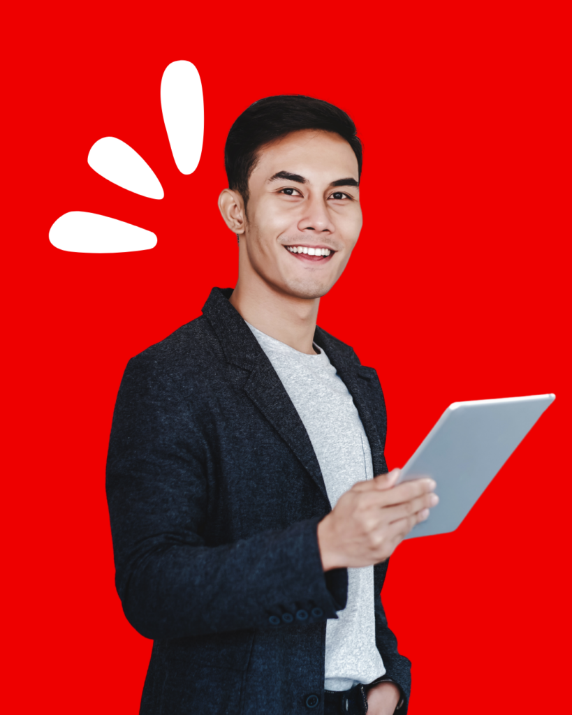 A smiling young man with short black hair, wearing a dark blazer over a light gray shirt, holds a tablet in one hand. He is standing against a bright red background with three white accent shapes resembling exclamation marks or stylized rays near his head, adding a dynamic and cheerful vibe.