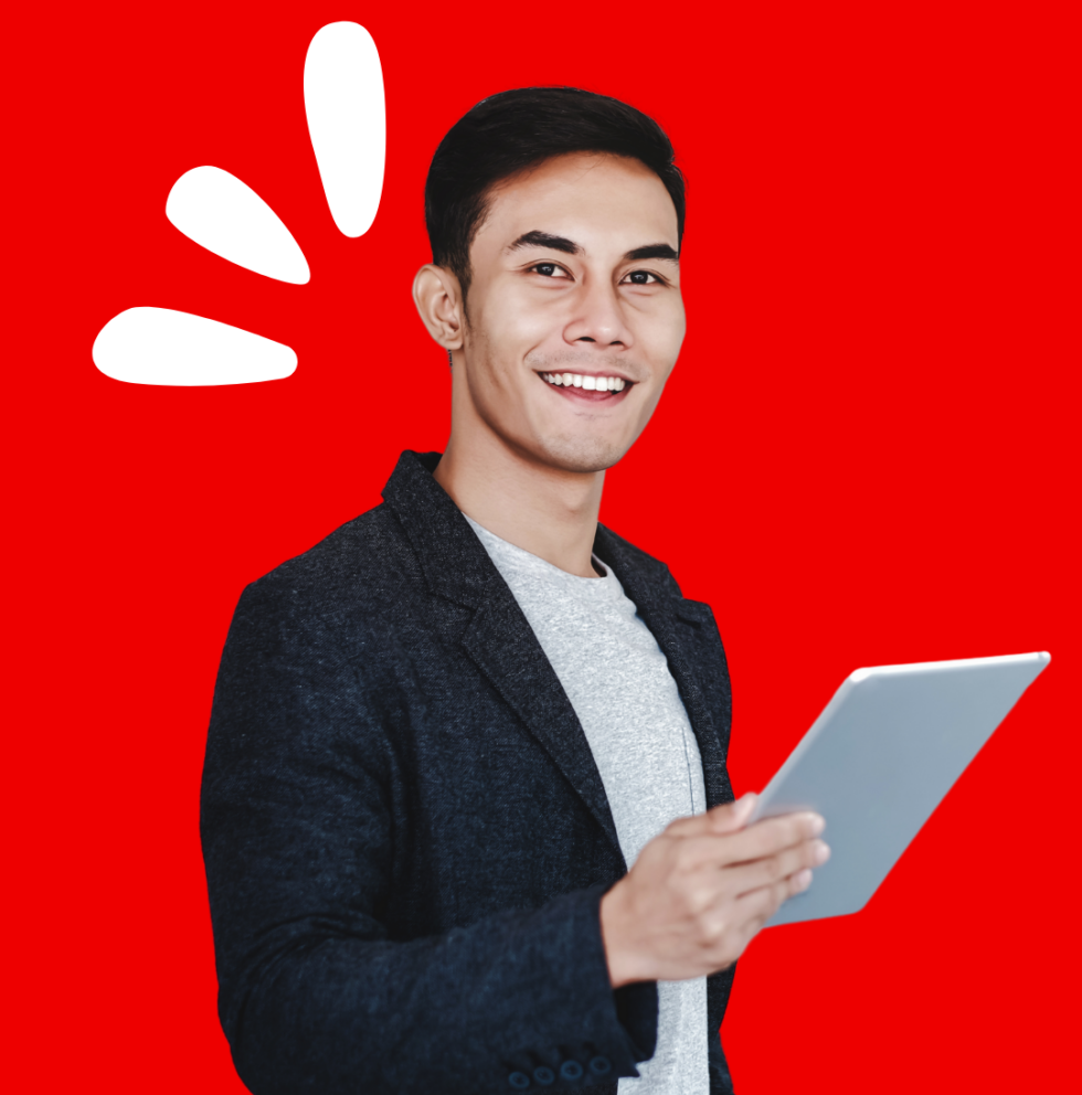 A smiling young man with short black hair, wearing a dark blazer over a light gray shirt, holds a tablet in one hand. He is standing against a bright red background with three white accent shapes resembling exclamation marks or stylized rays near his head, adding a dynamic and cheerful vibe.